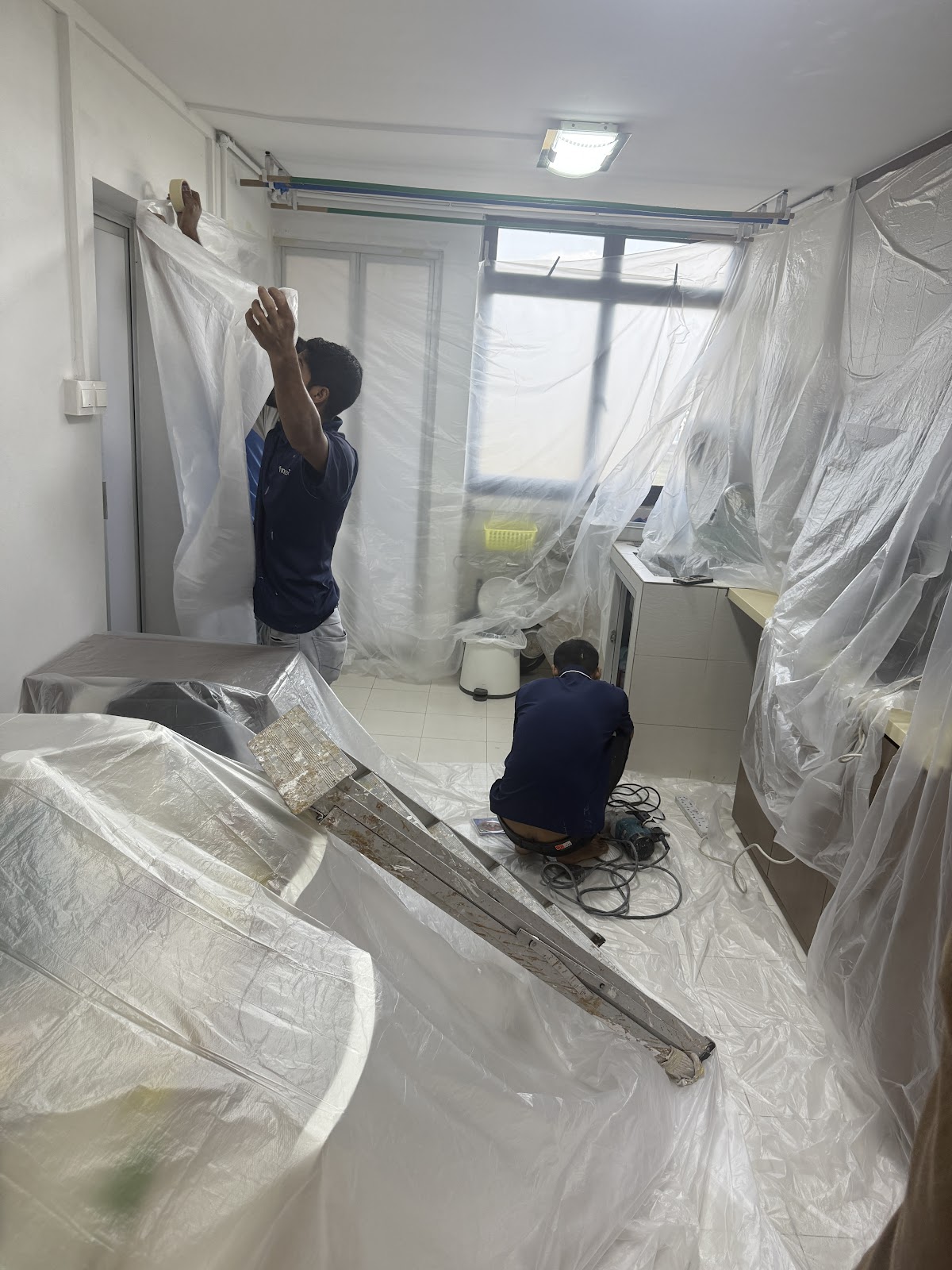 VoltSpark crew sheeting a kitchen in protective plastic before work begins